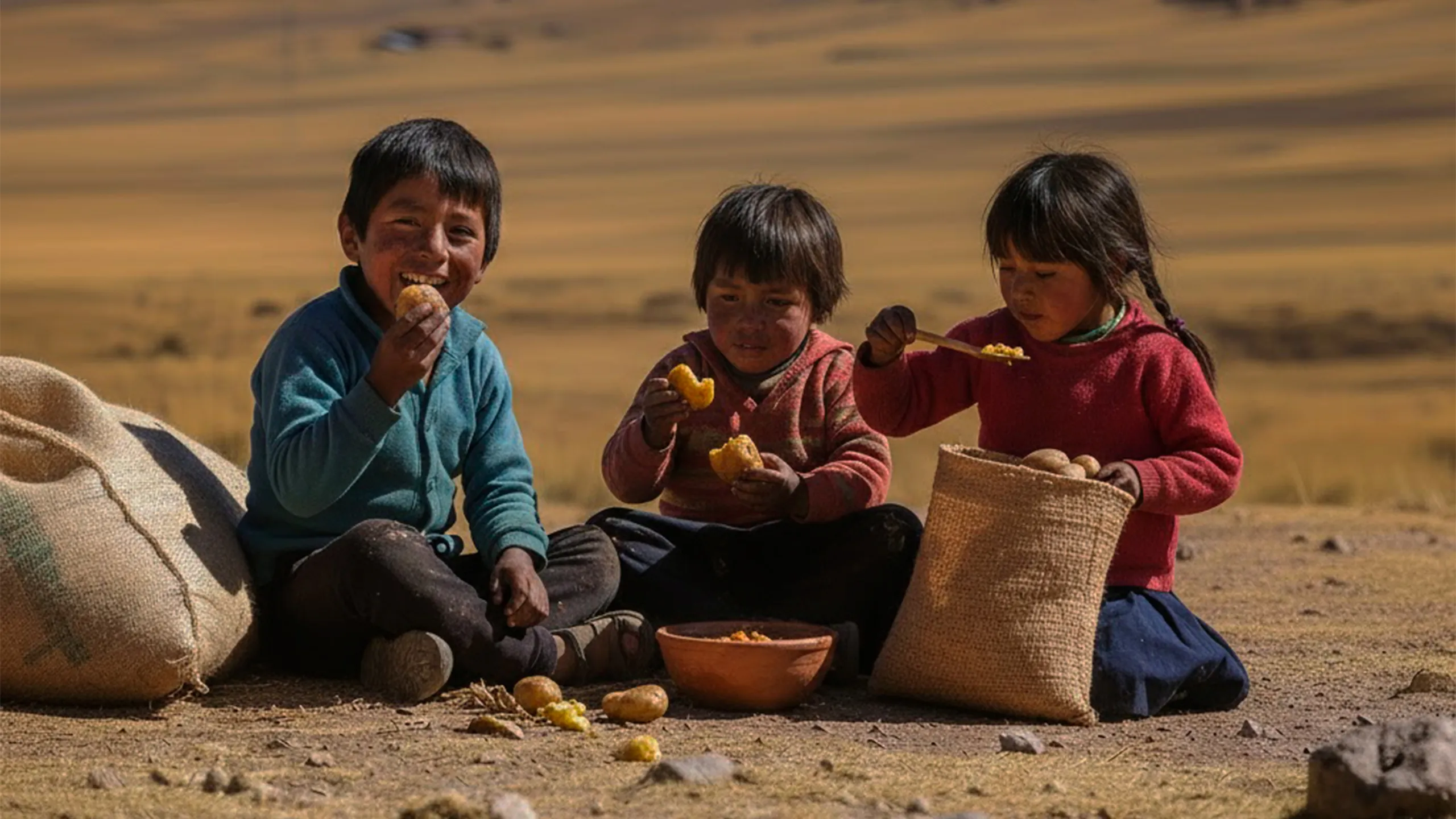 Niñas y niños de Huancavelica sentados en llantas en un patio escolar, contexto local de desnutricion infantil y trabajo comunitario de ASDEN